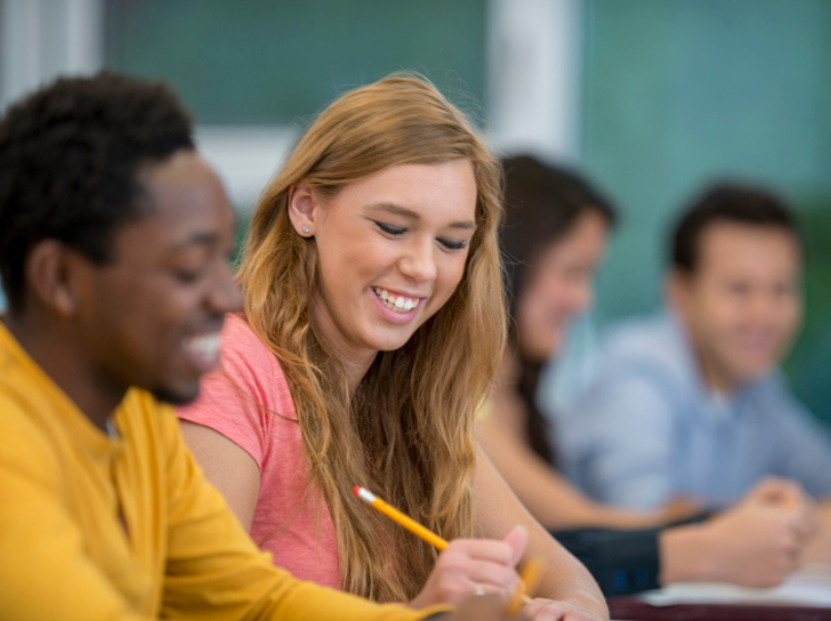 une fille qui sourit en étudiant 